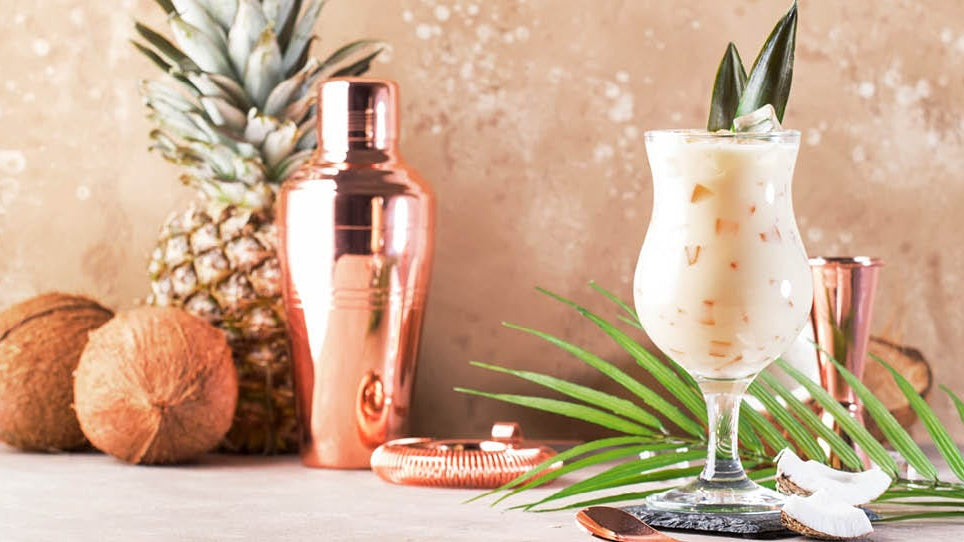 Cocktail, with a cocktail maker and pineapple and coconuts.