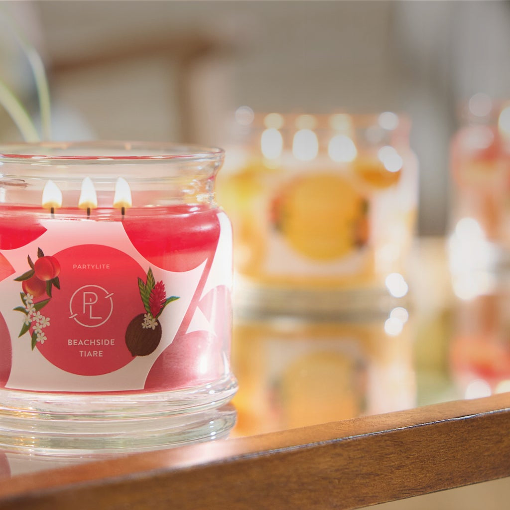 Several 3-wick jar candles on a table top.