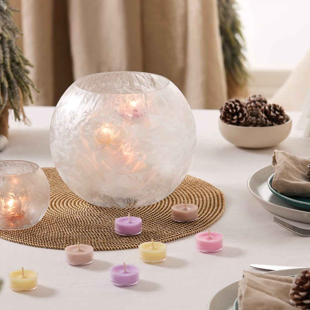 Crystalline Hurricane and Large Tealight Holder on a table with a white tablecloth along with tealights, place settings and pine tree decorations