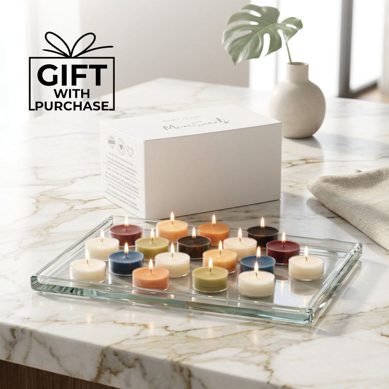 Various colored lit tealights on a glass tray on a kitchen worktop with the words "Gift with Purchase"