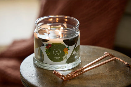 Lakeside Moss 3-Wick Candle lit with a candle snuffer