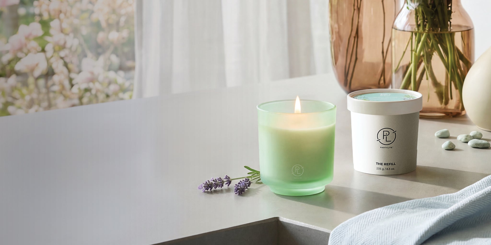 Refillable Green candle and white Refill container on a surface with a blurred background