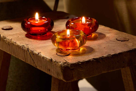 Lit Golden Honey Trio tealight holders on a wooden stool