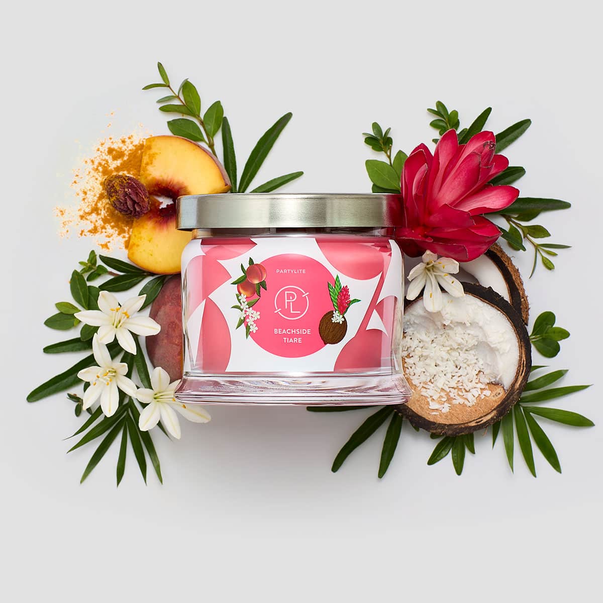 Beachside Tiare 3-Wick Jar Candle surrounded by flowers on a white background.