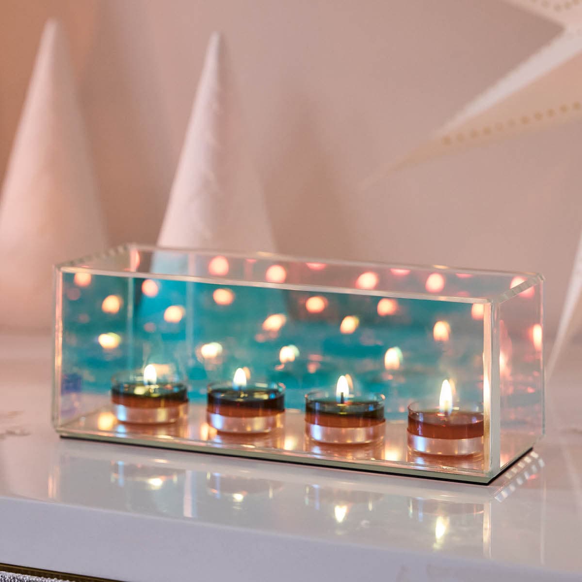 Infinite Reflections Centerpiece with four lit tealights against a light background.