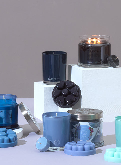 Multiple collections of jar candles, melts and tealights displayed on raised columns on a light surface