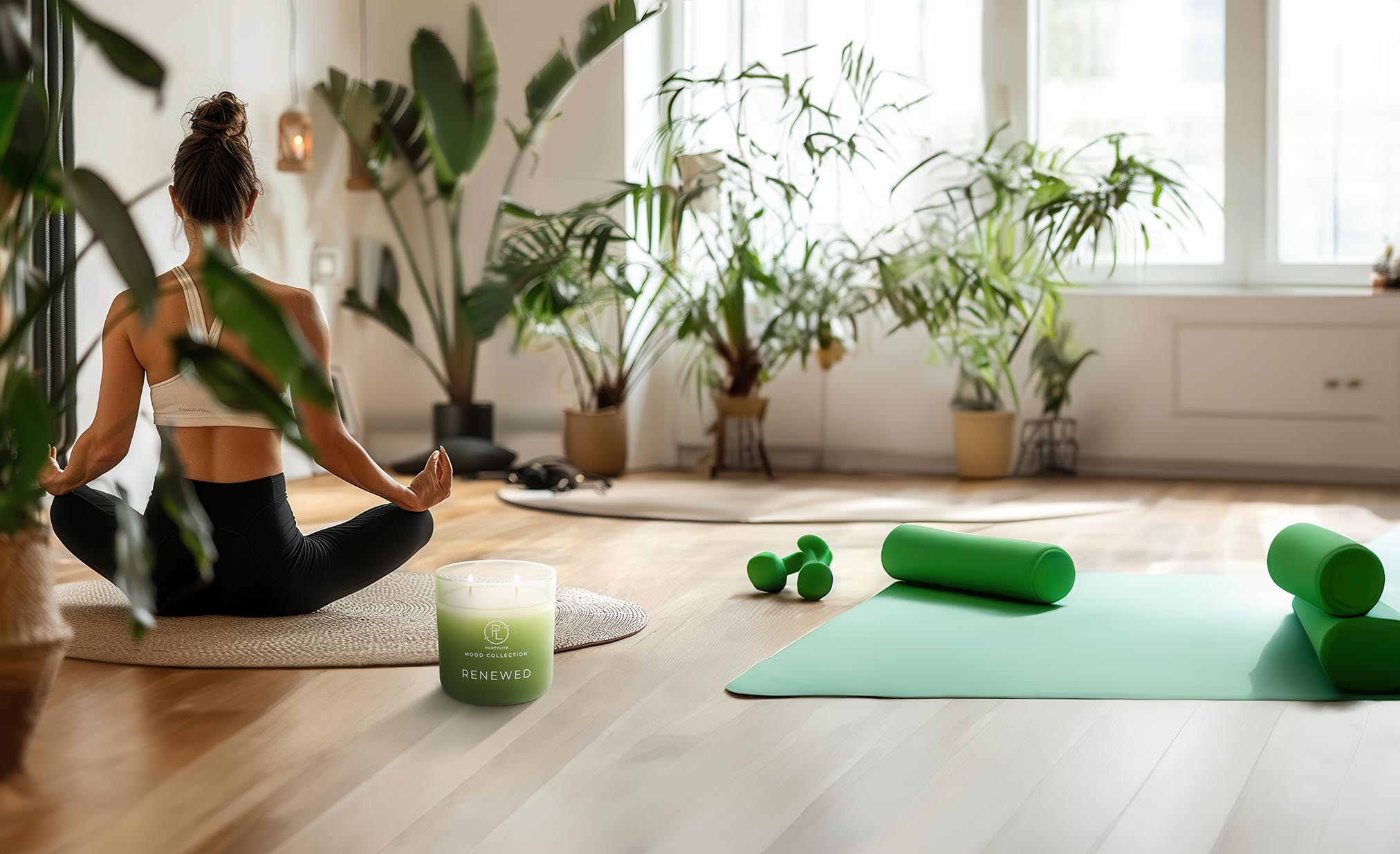 Renewed Mood Jar Candle sitting on a wooden floor with a lady practising Yoga with a green mat and floor plants.