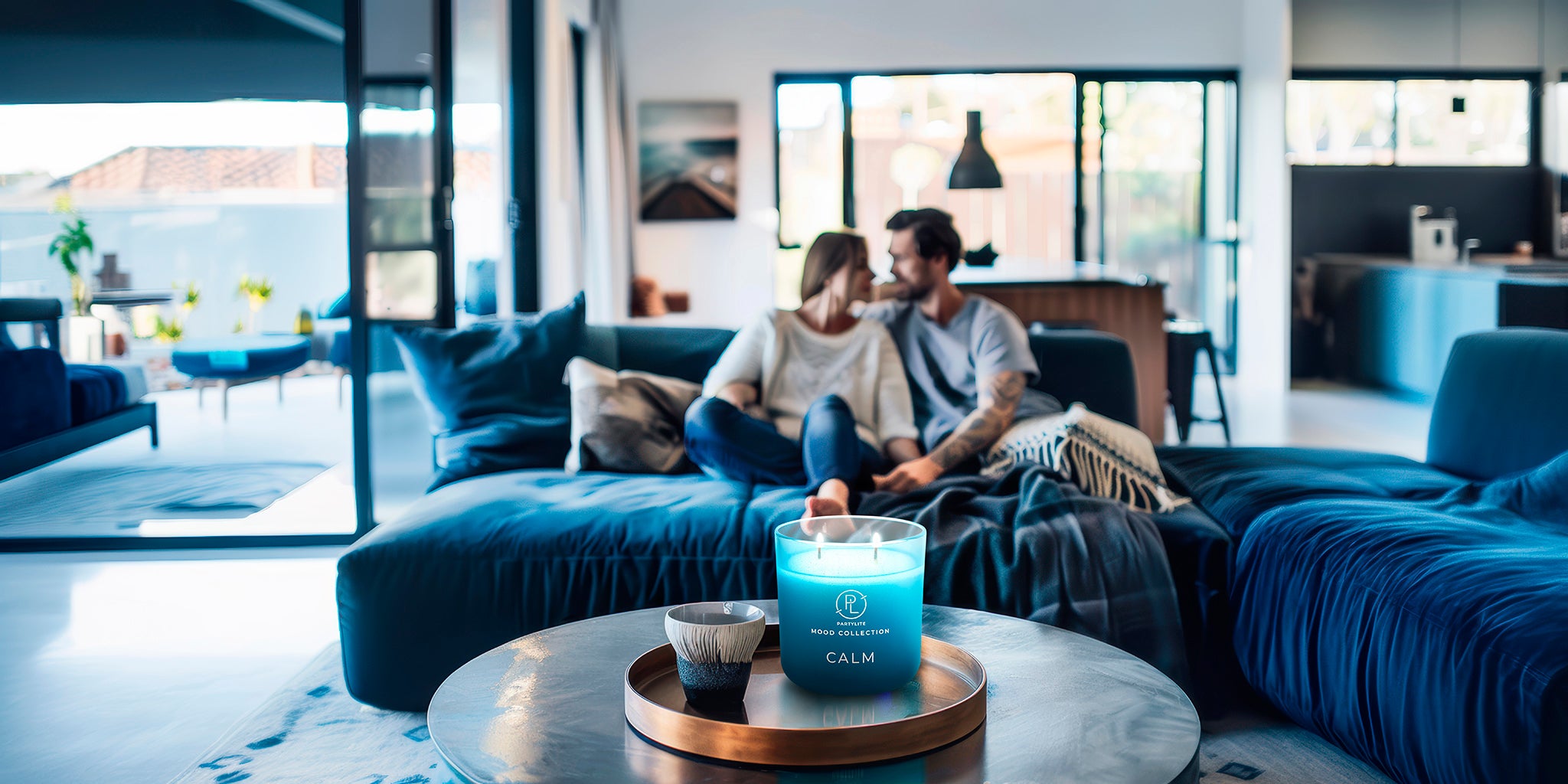 Calm Mood Jar shown on a wooden tray on a round table with blue sofas with a couple on, with windows in the background