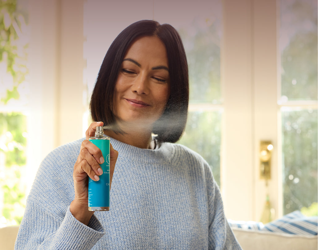 Woman spraying a Mood spray indoors