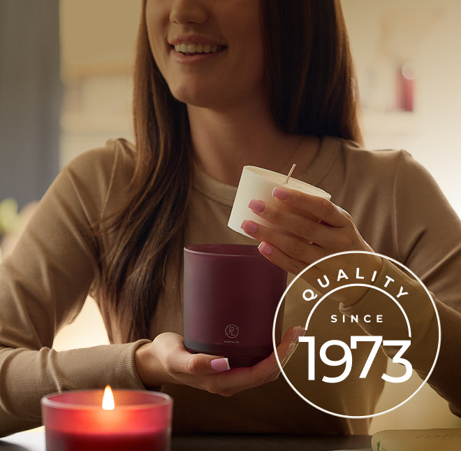 Woman holding a refillable jar candle with 'Quality Since 1973' logo.