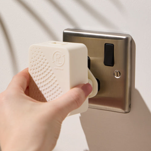Smart Plug in shown putting into a plug socket on a light background