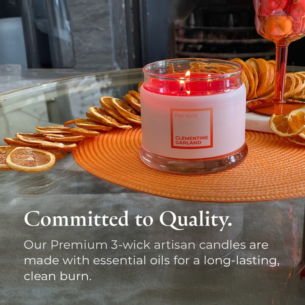 Clementine Garland 3-wick jar candle on an orange coaster with dried oranges with text showing the "Committed to Quality".