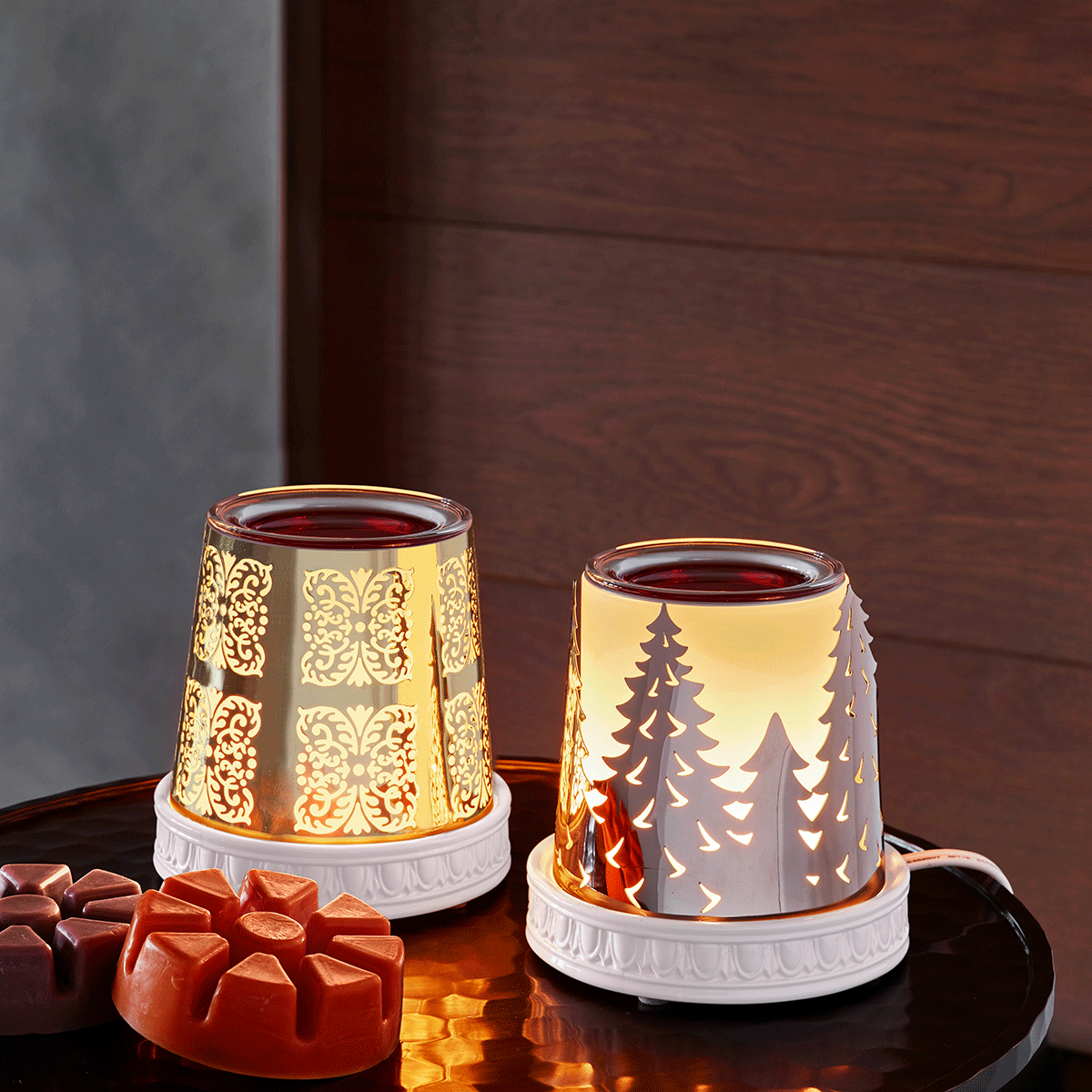 Two ScentGlow® Warmer – Winter Forest Changeables next to each other on a round table with ScentPlus melts