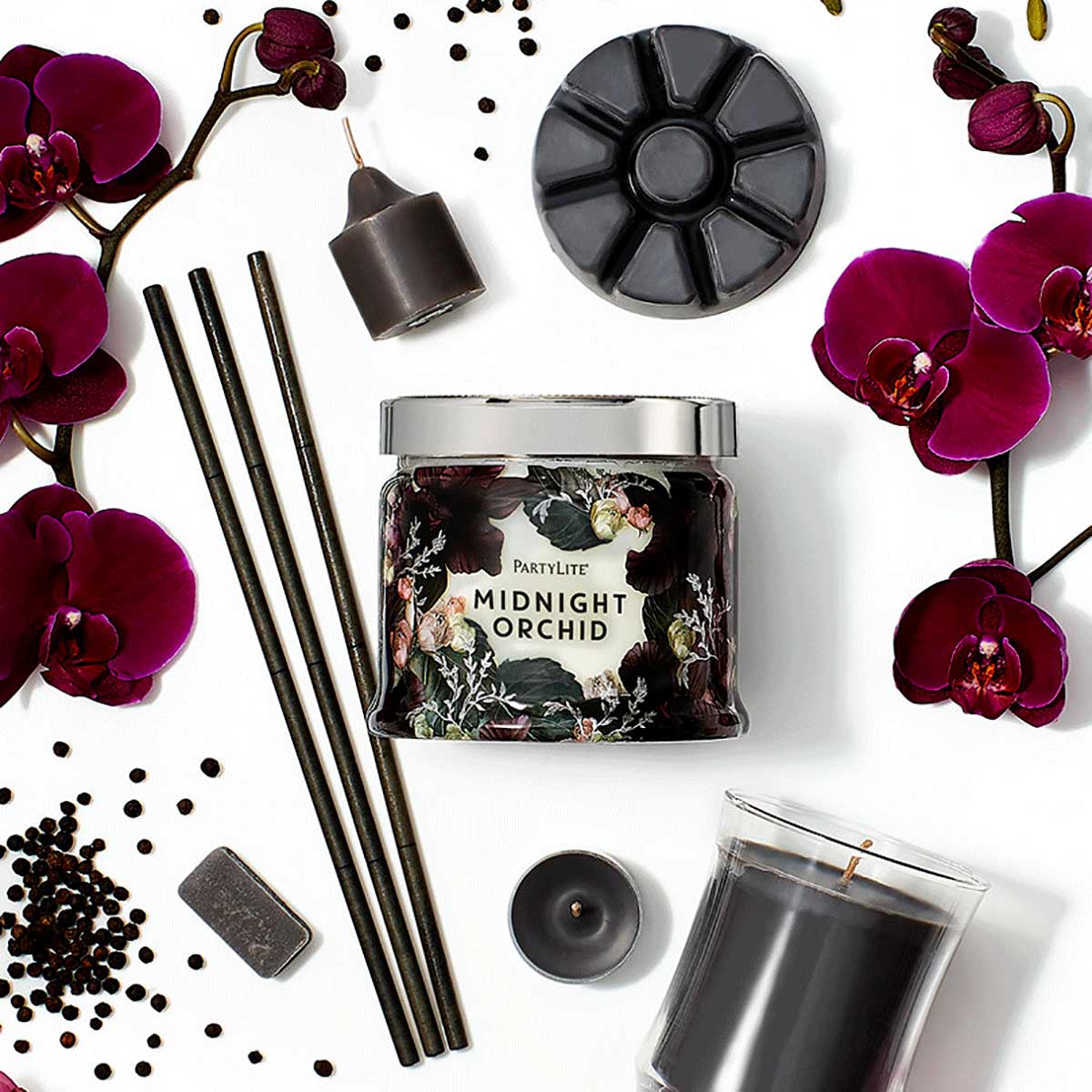 Midnight Orchid 3-wick jar candle, fragrance sticks, escential jar, votive, tealight and wax melts shown with burgundy flowers and black seeds against a white background.