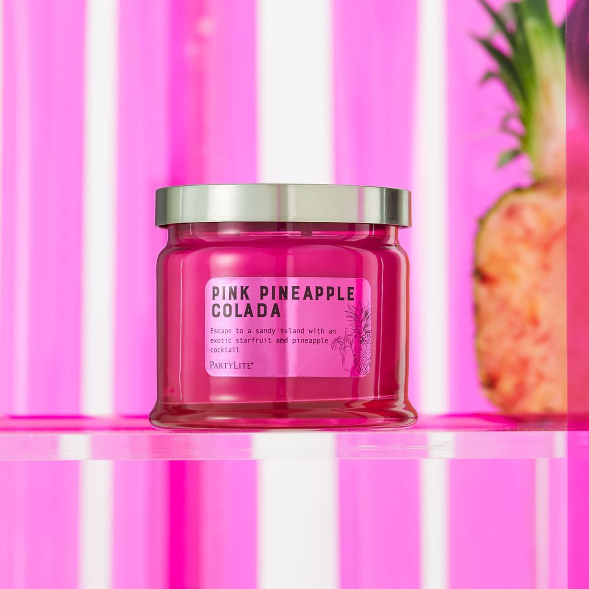 Pink Pineapple Colada 3 Wick Jar Candle against a pink and white stripy background.