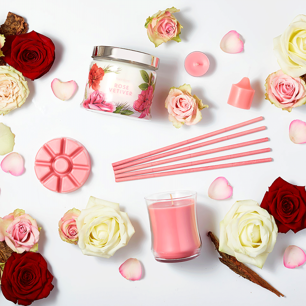 Rose Vetiver 3-wick jar candle, votive, fragrance sticks, tealight, wax melts, surrrounded by pink, red and white roses on a white background.