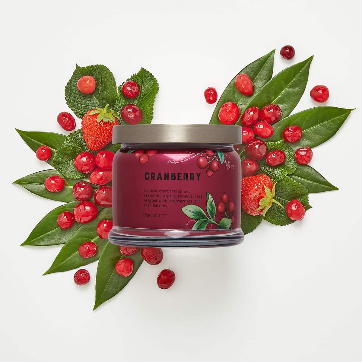 Cranberry 3-Wick Jar Candle surrounded by berries and leaves against a white background.