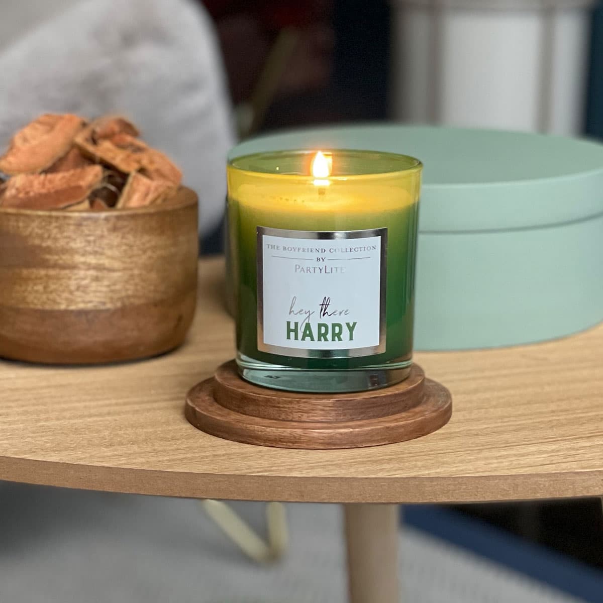 "Harry" Boyfriend Jar Candle – Watermelon fragrance, showing lit on a wooden coaster on a wooden table.