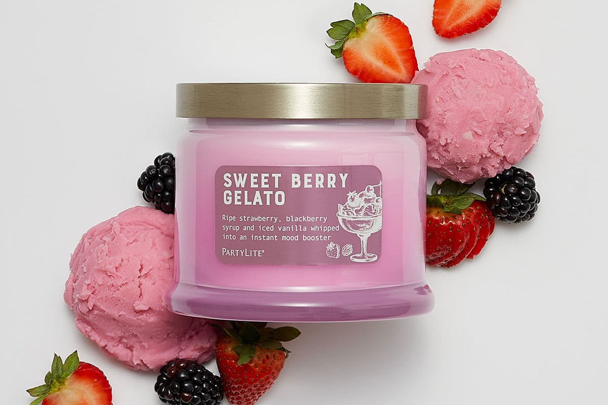 Sweet Berry Gelato 3-Wick Jar Candle surrounded by pink icecream and strawberries and blackberries on a white background.