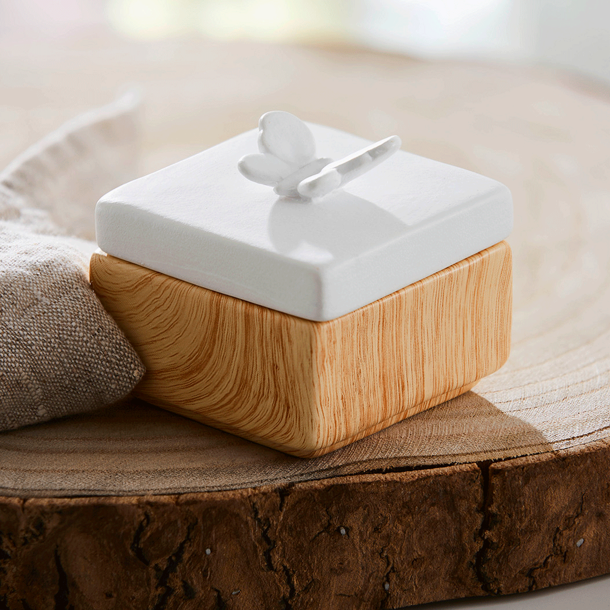 Spring Pals Tealight Candle Holder Trio wooden bases with white lids.
On this lid a butterfly and the tealight holder shown on a wooden surface.