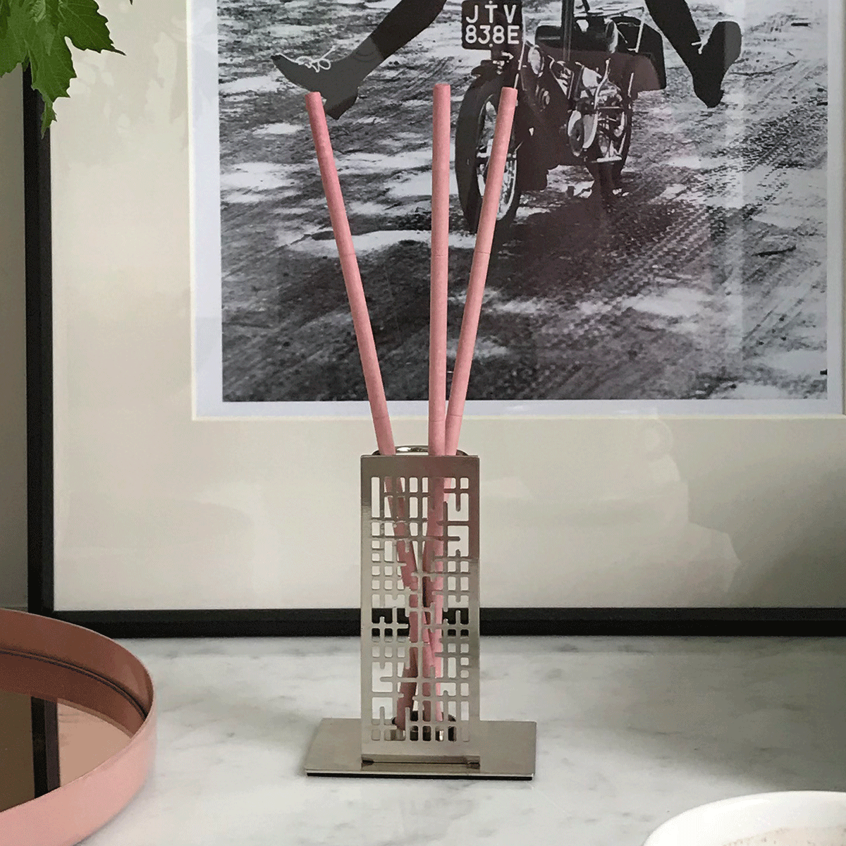 Contempo silver metal smart scents holder shown with fragrance sticks on a light surface with a poster in the background.