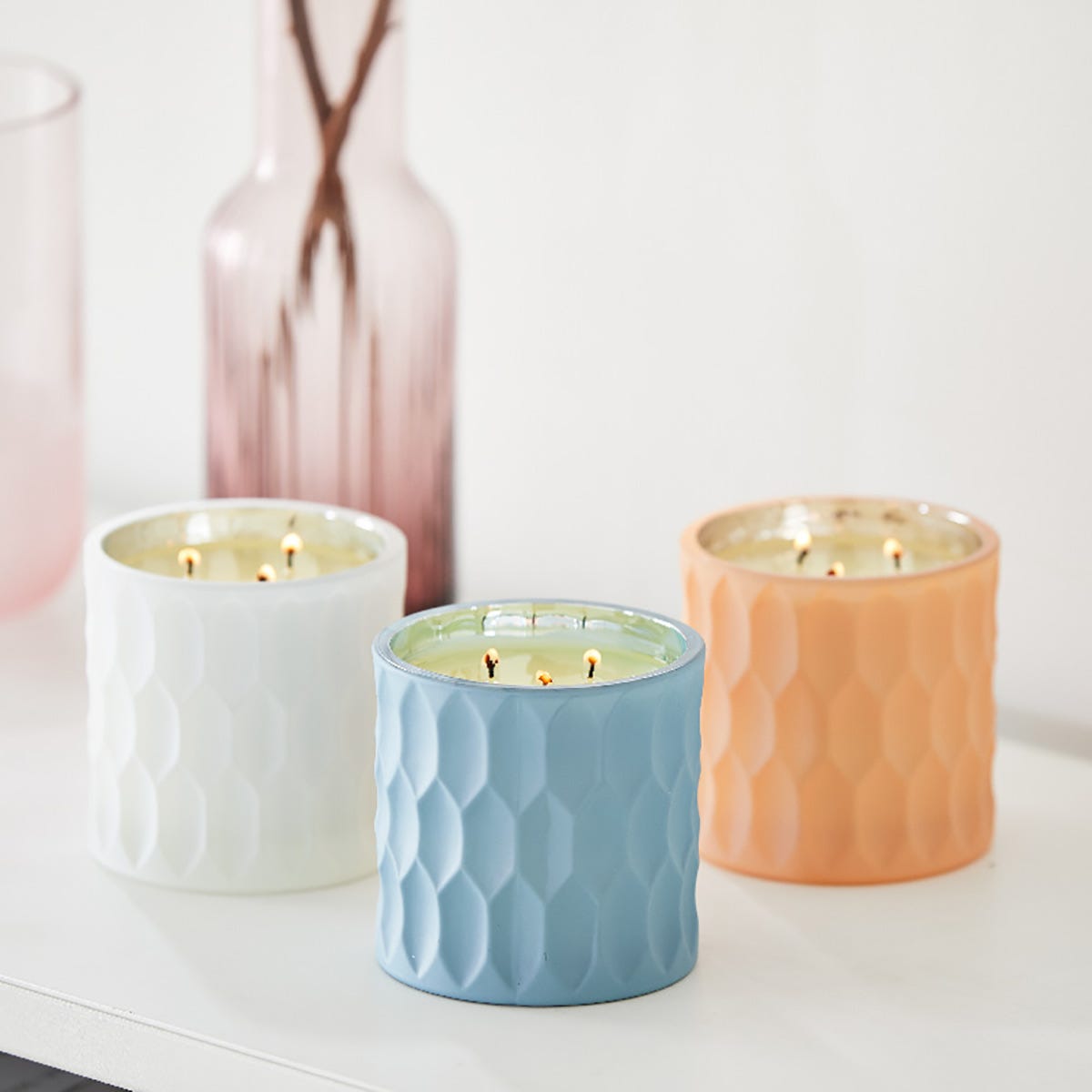 3 different colored sparkling jars against a white background.