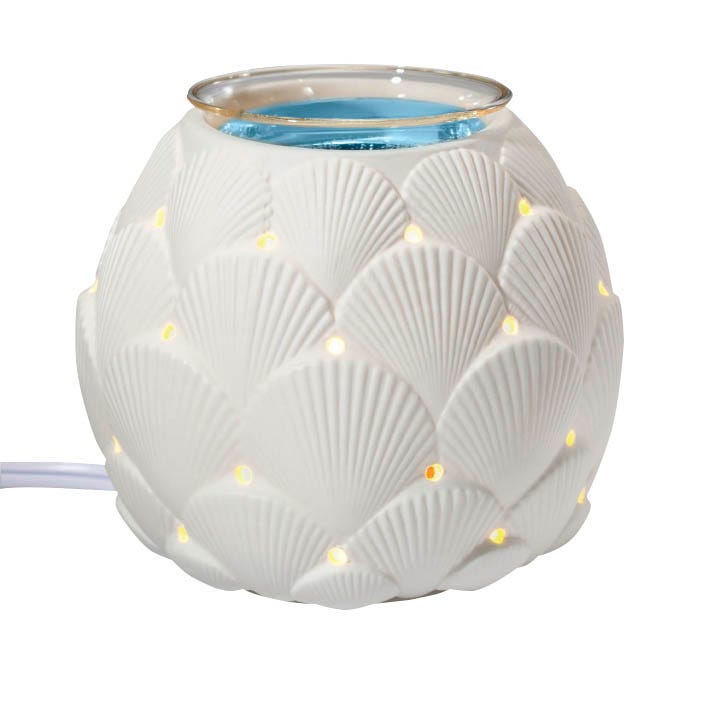 White ceramic Seashell scent glow warmer against a white background.