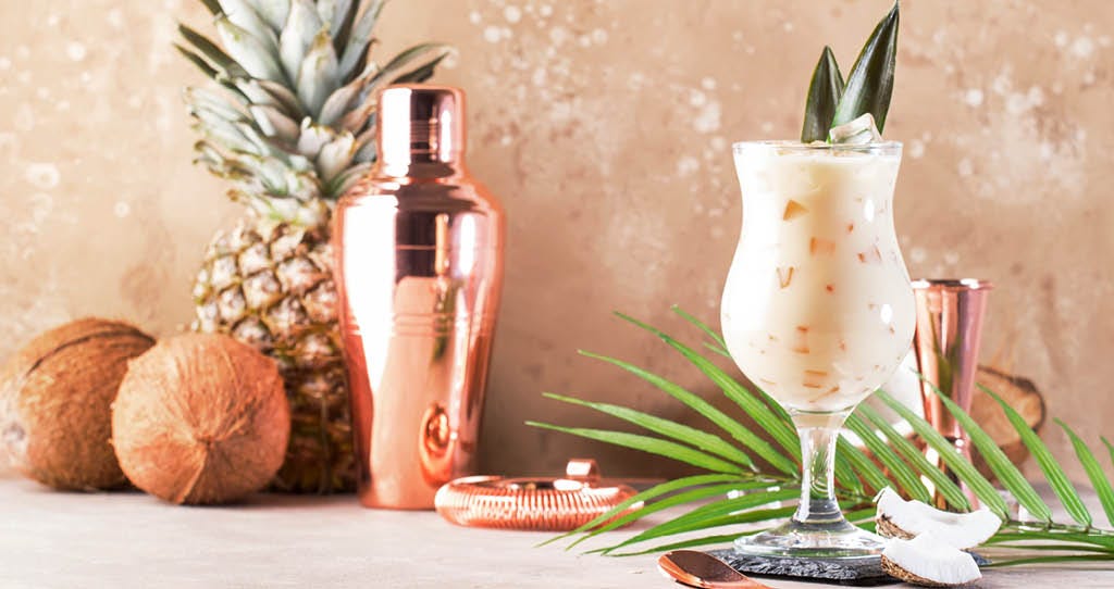 Cocktail, with a cocktail maker and pineapple and coconuts.