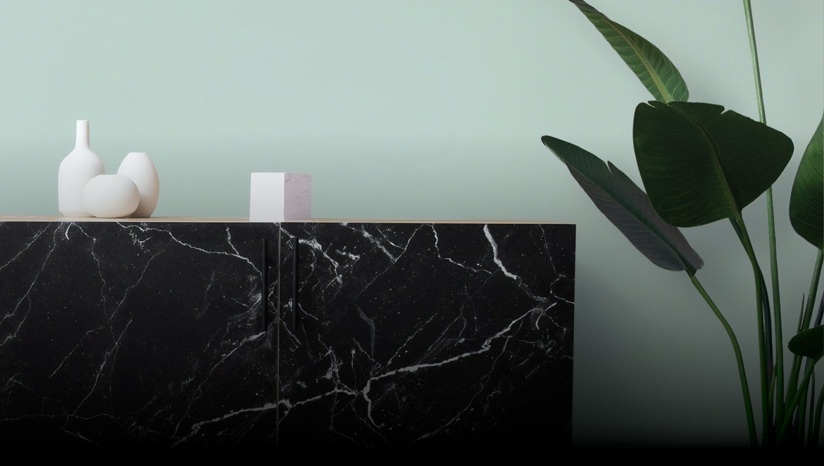 Dark colored sideboad with white decorative items next to a house plant.