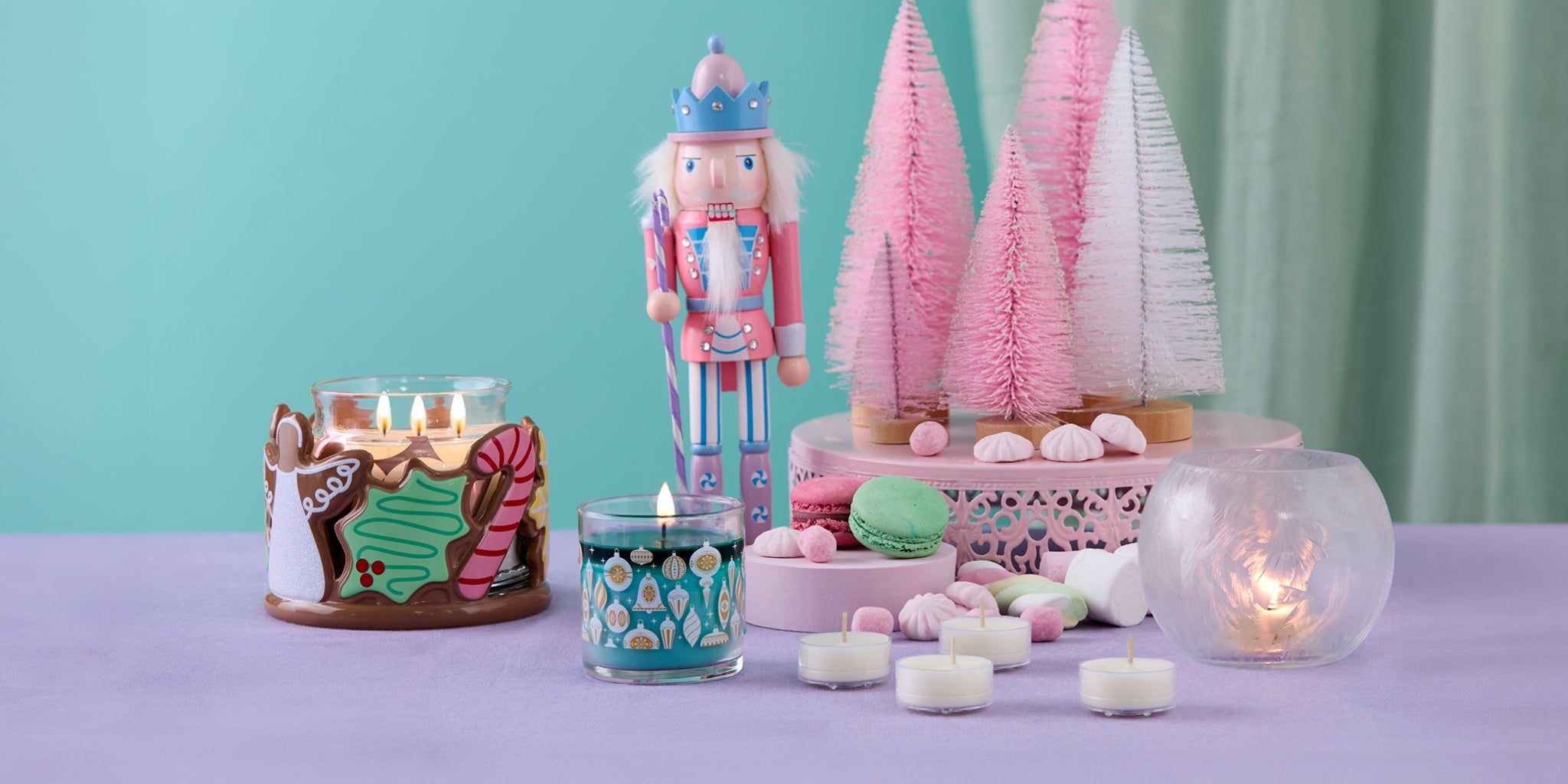 Christmas scene with bottle brush trees and a nutcracker. Candle holder with cookie images, a mini jar, and a crystaline tealight holder.