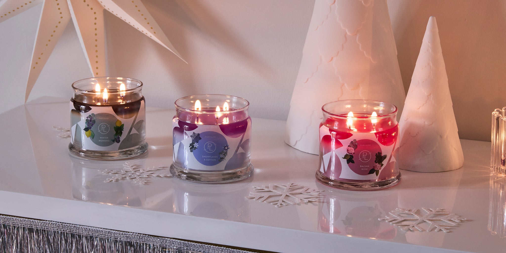 PartyLite 3-Wick Jar candles in a winter scene with White decorative trees