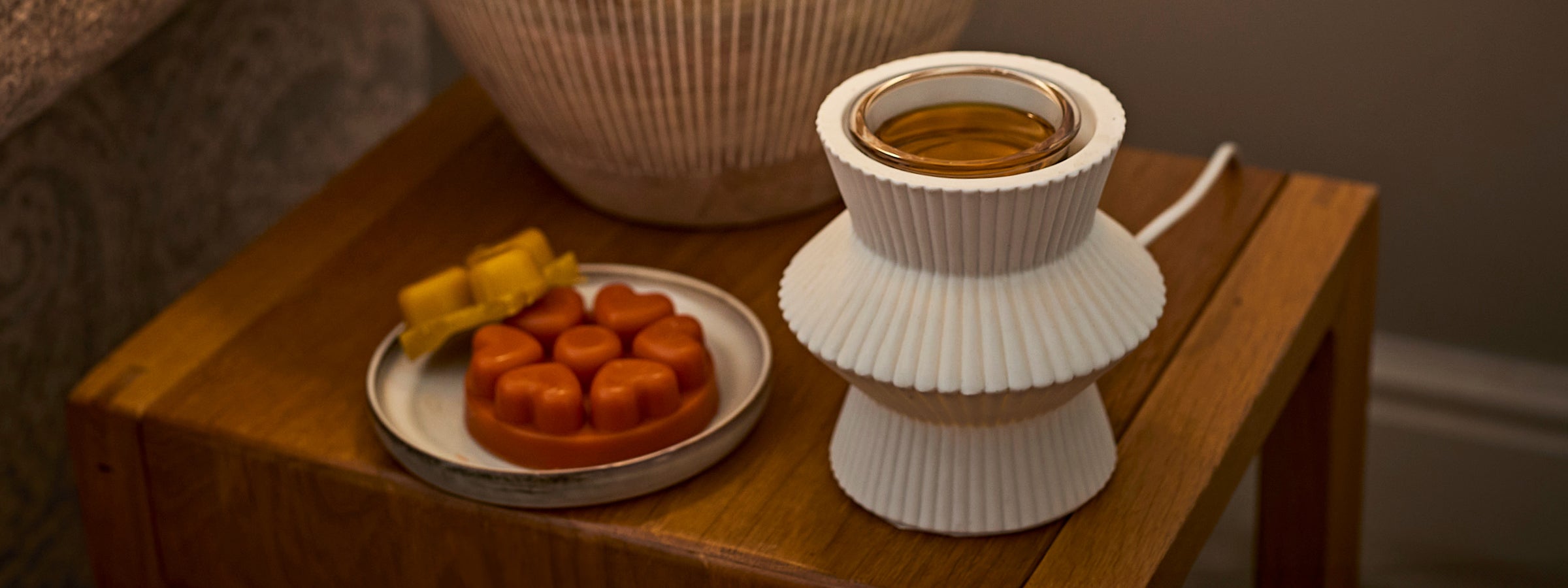Pinstripe Wax Melt Warmer on a wooden table with a plate of heartshaped wax melts