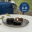 Three black tealight candles on a silver tray with a blue circle displaying 'Burns up to 4-6 hours' text.