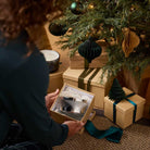 Winter Morning 3-Wick Ripple Jar Candle shown in Christmas box being held by a lady next to a Christmas Tree.