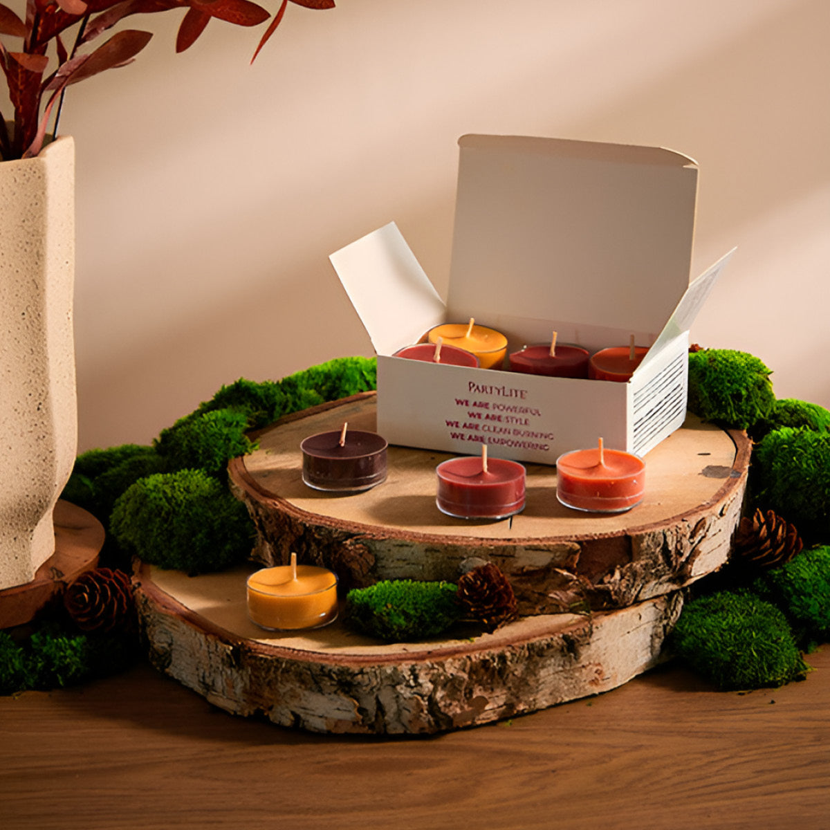 Autumn Woods Tealight Sampler with an assortment of colorful tealights on wooden log trays with moss 