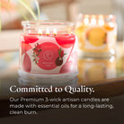 Lit candle in a glass jar with a visible brand label, surrounded by soft lighting.