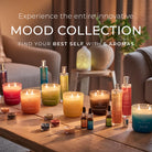 Mood collection of candles, oils and room sprays on a wooden table with a cozy living room background.