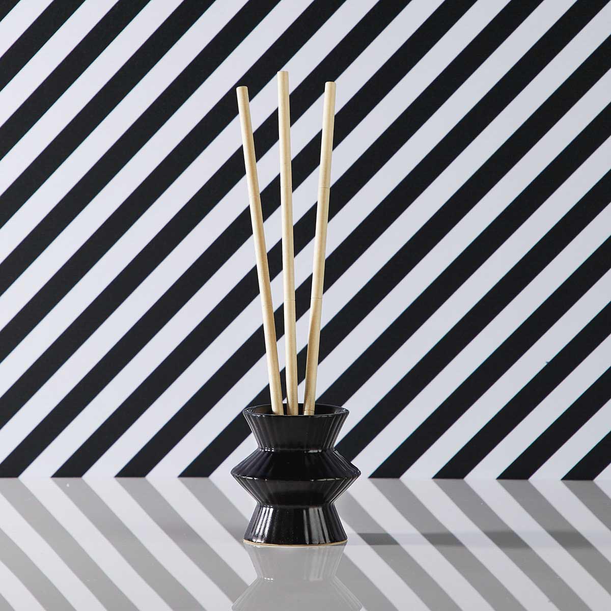 Black Pinstripes Fragrance Holder shown with fragrance sticks against a black and white strippy background.