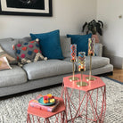 Tribal Chic Raised Tealight Holder Trio colorful pattern cups on a gold stand shown on table in a living room setting.