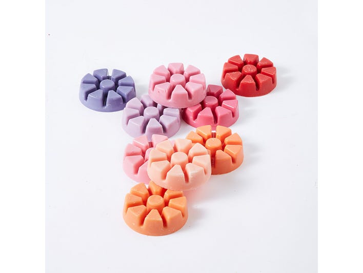Various colored wax melts against a white background.