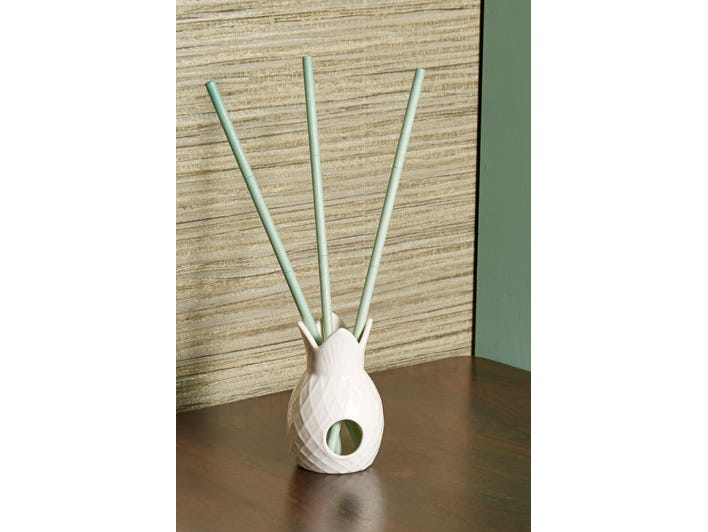 Gardenia Palm Fragrance Sticks in a pineapple shaped white fragrance stick holder on a wooden surface.