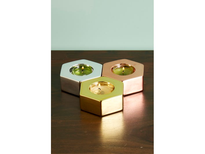 Metallic Hexagon Tealight Trio shown with lit tealights on a wooden surface.