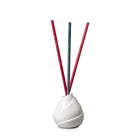 White Waves Fragrance stick holder, against a white background, with red and green fragrance sticks.