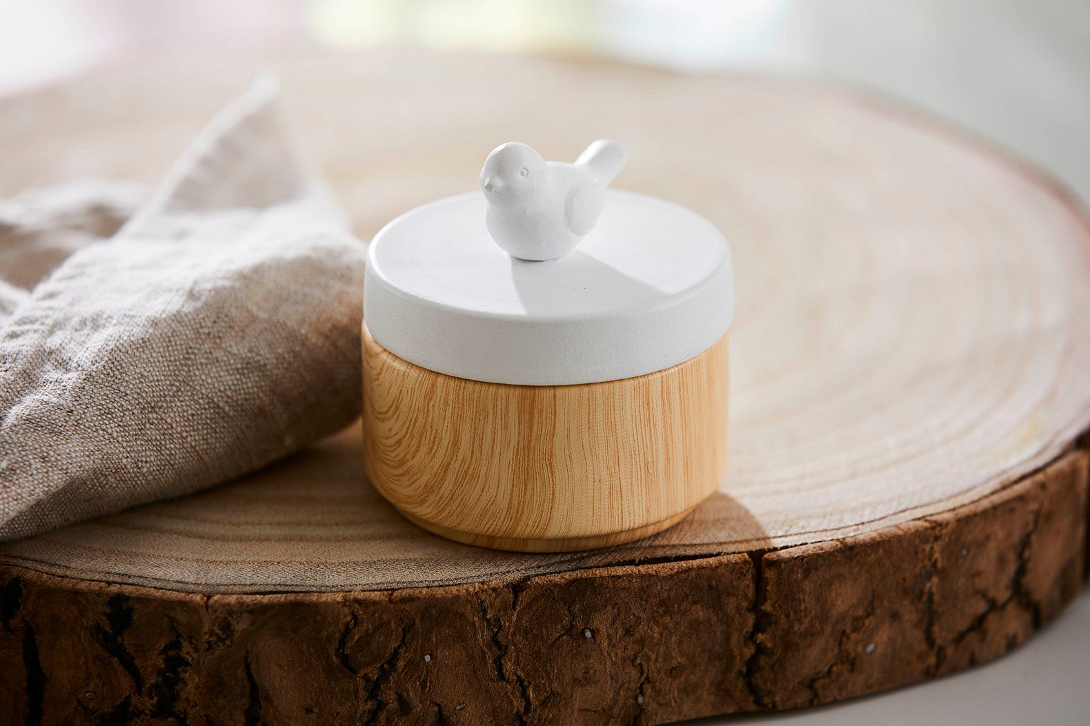 Spring Pals Tealight Candle Holder Trio wooden bases with white lids. 
On this lid a bird and the tealight holder shown on a wooden surface.