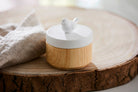 Spring Pals Tealight Candle Holder Trio wooden bases with white lids. 
On this lid a bird and the tealight holder shown on a wooden surface.