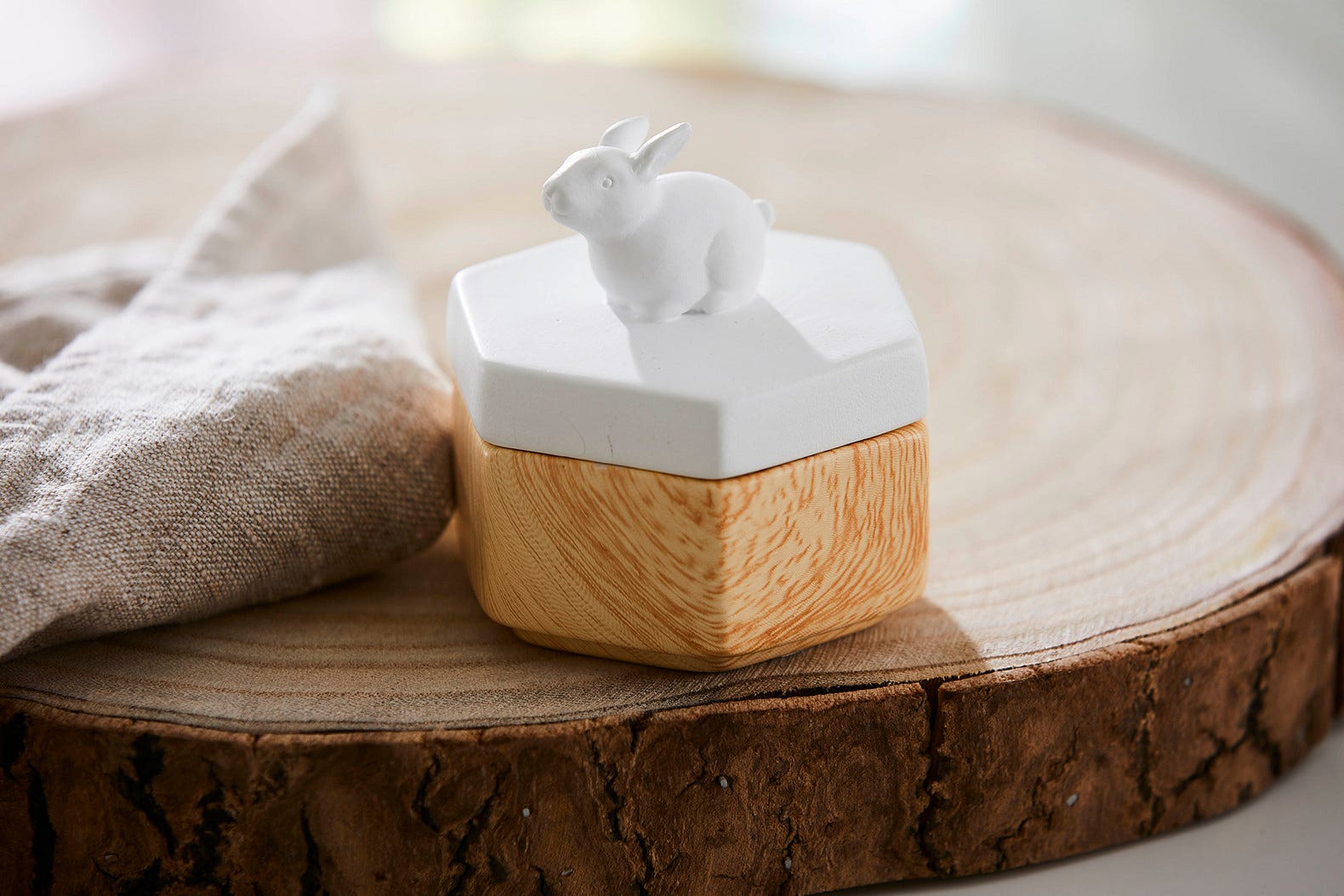 Spring Pals Tealight Candle Holder Trio wooden bases with white lids. 
On this lid a rabiit and the tealight holder shown on a wooden surface.