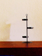  Bronze-toneTealight tree, shown with lit tealights on a wooden surface against a light backgrtound.